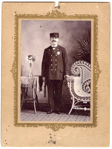 Cabinet photo of a U.S. Marshall with a Wyatt Earp mustache, billy club, cap, and badge...
