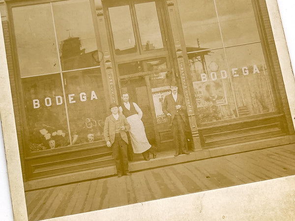 Three men outside The Bodega, Brainerd, MN ca. 1895 (cabinet card)