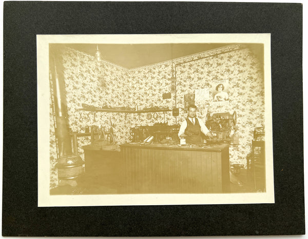 Photograph of a cobbler at the repair counter, ca. 1930s