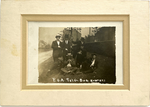 Photograph of seven young men, "P. & A .Tel. Co. Bug Hunters" (RPPC)