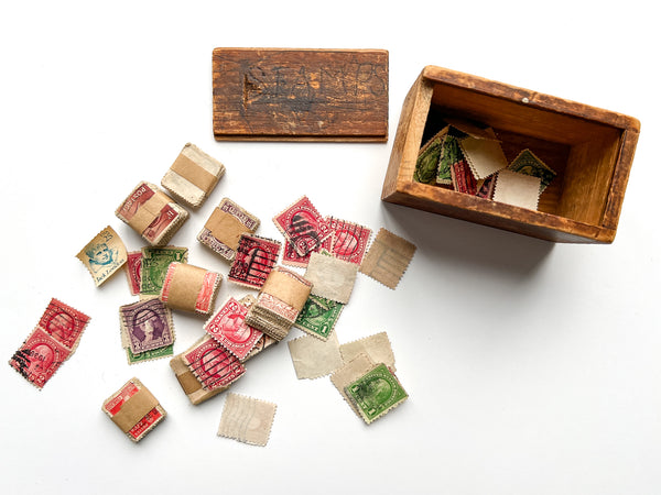 Wooden slide-top box full of hundreds of U.S., British and Belgian stamps.