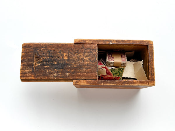 Wooden slide-top box full of hundreds of U.S., British and Belgian stamps.