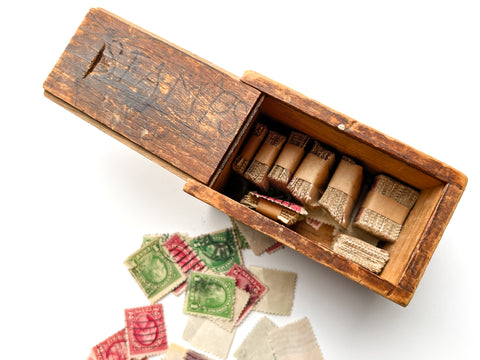 Wooden slide-top box full of hundreds of U.S., British and Belgian stamps.