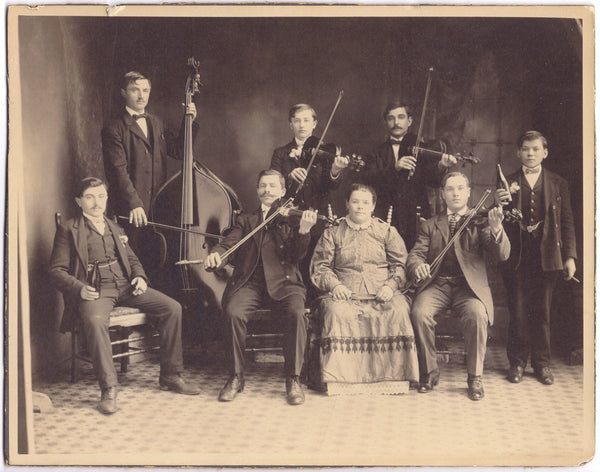 Mounted photograph of a string band with weary hosts at a private event