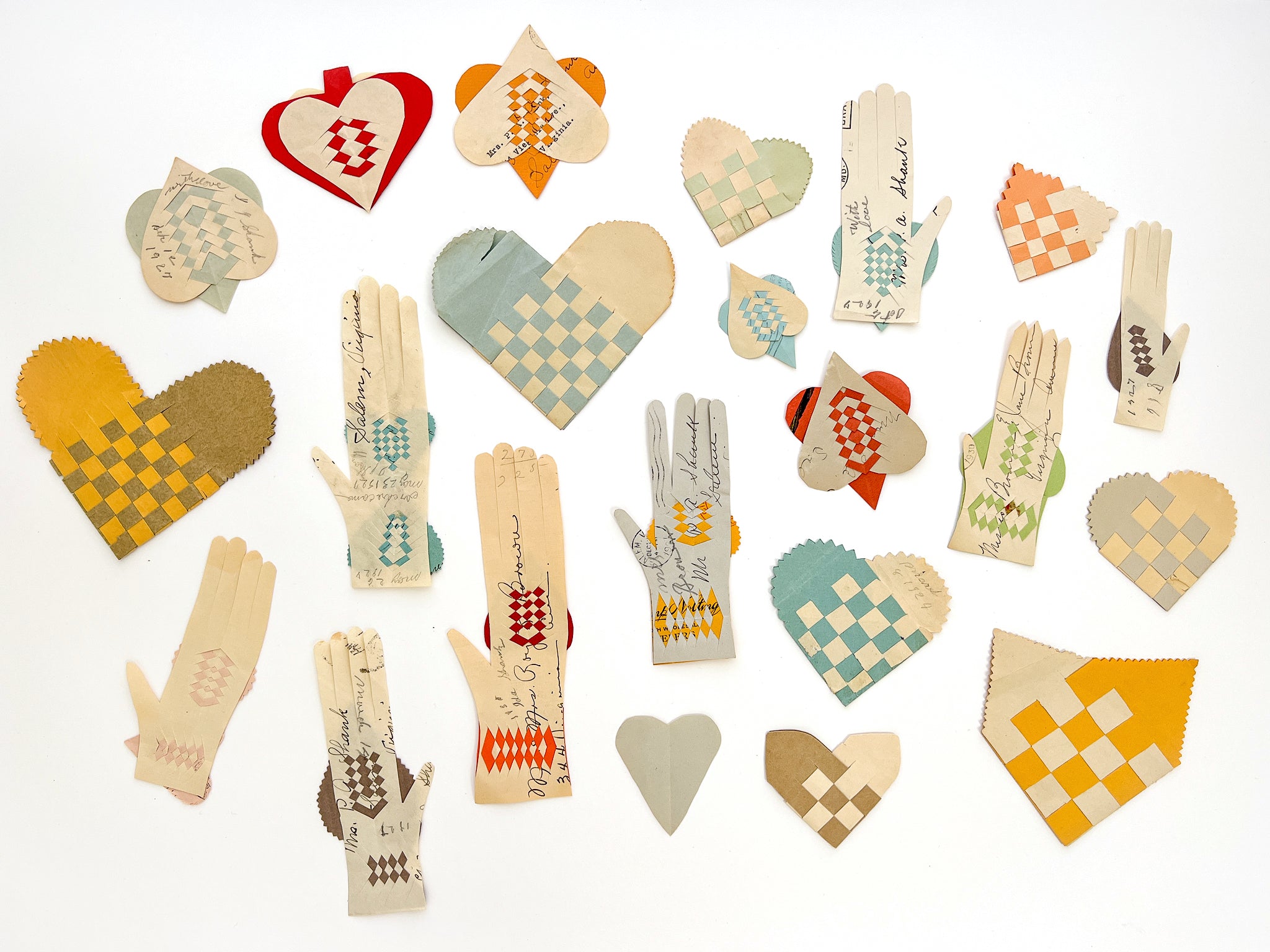 Collection of 22 woven paper pockets and heart-in-hand love tokens
